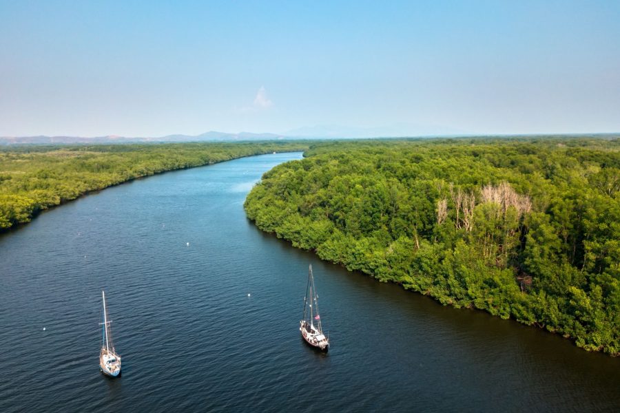 A pair of anchored sailboats in the middle of a mangrove canal in the Jiquilisco bay, Usulután, El Salvador.