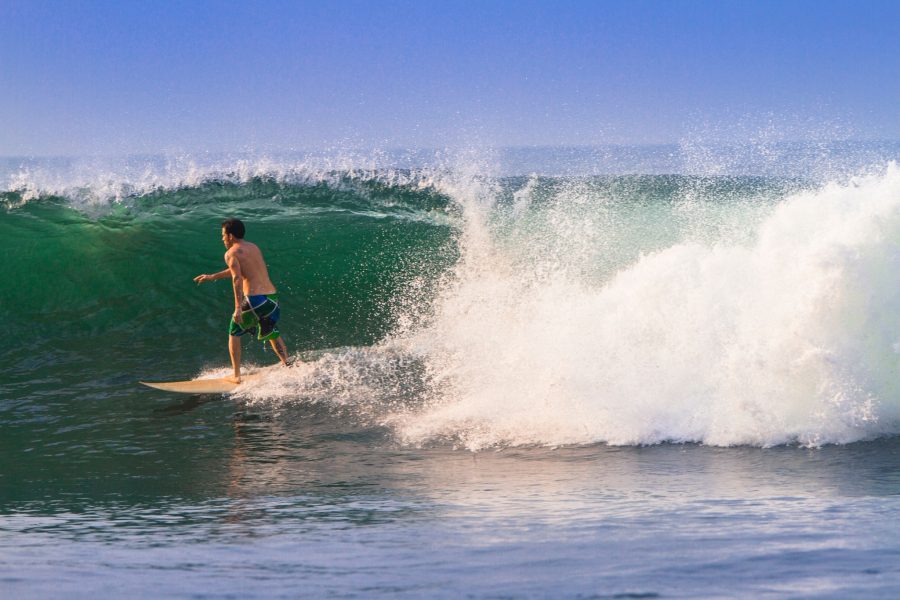 Surfer in a barrelling wave on beach in  El Salvador.